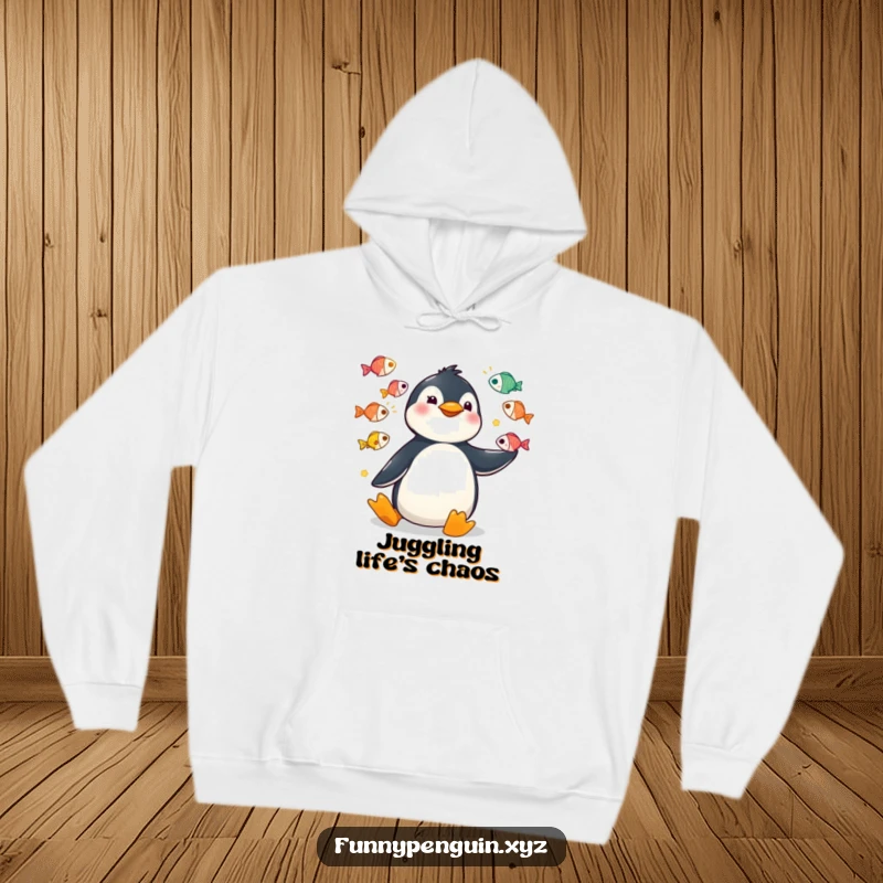 Funny hoodie depicting a kawaii penguin juggling colorful fish with highly exaggerated, funny movements.